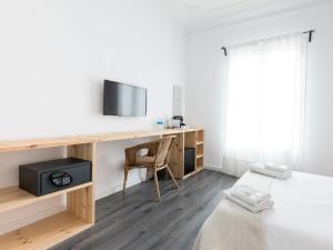 a room with a desk with a tv and a chair at Bruc & Bruc in Barcelona