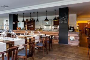 um restaurante com mesas e cadeiras de madeira e uma cozinha em Pural - Wool Valley Hotel & SPA na Covilh