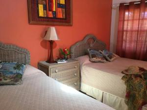 a bedroom with two beds and a lamp on a night stand at Paradise Beach Hotel in Kingstown