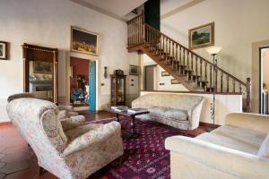 a living room with two chairs and a staircase at Casa Vacanze Villa il Castellaccio in Lucolena in Chianti