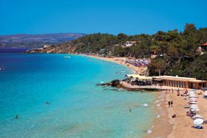 a beach with umbrellas and people in the water at Sofia's Delightful Apartment in Argostoli