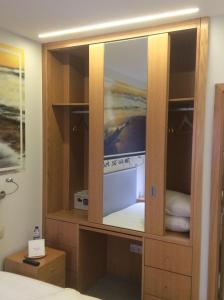 un armario de madera con un televisor en su interior en Guest House A&z, en Espinho