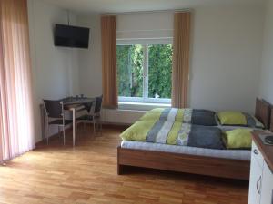 a bedroom with a bed and a table and a window at Koxsi's Motorhome in Spielberg