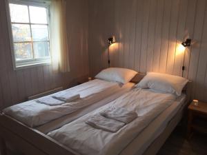 a large bed in a bedroom with two towels on it at Skei Apartments in Svingvoll