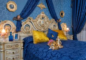 a bed with a blue and white bedspread next to a lamp at Scalon del Doge in Venice