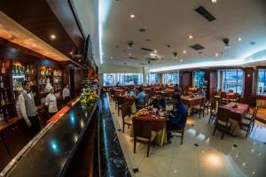 un restaurant avec des tables et un bar dans l'établissement Hotel Emperador, à Ambato