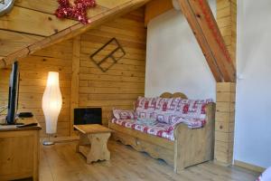 Habitación con cama en una cabaña de madera en Appartement Le Chalet, en Ornans