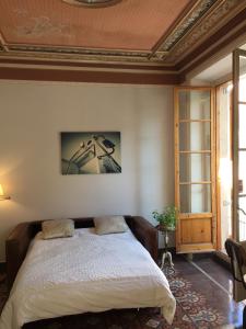 1 dormitorio con cama y techo artesonado en Piso Vilanova i la Geltrú, en Vilanova i la Geltrú