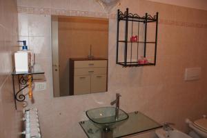 a bathroom with a glass sink and a mirror at La Sorgente Apartment with private pool in Calice Ligure +27 photos