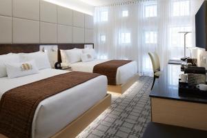 una habitación de hotel con dos camas y un escritorio en Le Mount Stephen, en Montreal 28 fotos más