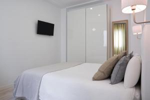 a bedroom with a white bedspread and white pillows at Luxury Apartment Picasso in Málaga