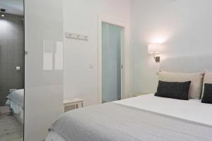 a hotel room with a white bed and white walls at Luxury Apartment Picasso in Málaga