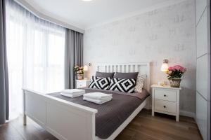 Habitación blanca con cama grande con almohadas en Horyzont Luksusowe apartamenty nad morzem z parkingiem en Międzyzdroje