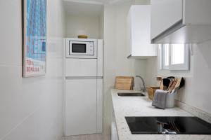 a kitchen with a white refrigerator and a microwave at Luxury Apartment Picasso by Nagoa Homes in Málaga