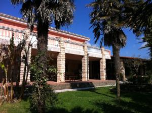 a building with palm trees in front of it at Agave Alghero in Fertilia