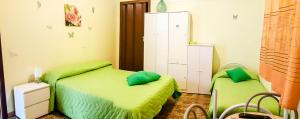 1 dormitorio con 2 camas y almohadas verdes en Beb I Delfini Di Casa Paola, en Mascali