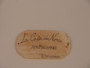 La Casa dei Nonni في Torre Orsina: a wooden sign that reads la casa old norman apartments agency