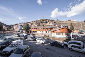 a parking lot with cars parked in front of a mountain at Plaza Valberg centre studio cabine in Valberg