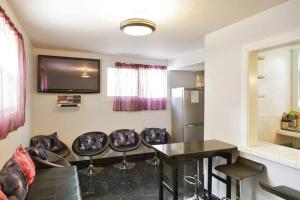a living room with a table and chairs and a television at Orange Drive Hostel in Los Angeles