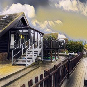 una pintura de una casa con un tren en ella en Isleham River Lodge, en Isleham