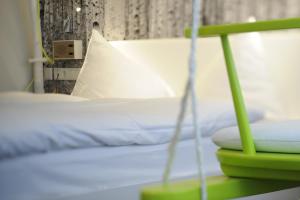a bed with a green frame and a white pillow at Hotel Saalbacher Hof in Saalbach-Hinterglemm