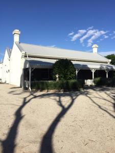 a white building with a shadow of a tree at Little River Bed and Breakfast in Little River