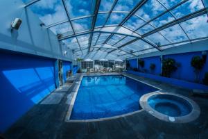 une piscine intérieure avec un plafond en verre dans l'établissement Hotel Emperador, à Ambato