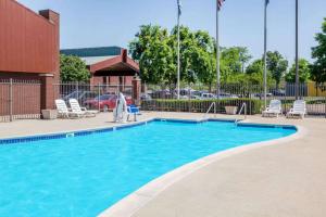 a large swimming pool with lounge chairs and a swimming pool at Baymont by Wyndham Elkhart in Elkhart