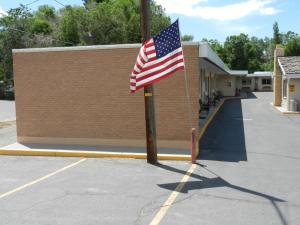 Una bandiera americana su un palo in un parcheggio di Paintbrush Motel a Riverton