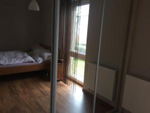 espejo en una habitación con cama y ventana en Apartament Ella en Międzywodzie