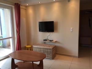 a living room with a table and a tv on the wall at Apartament Ella in Międzywodzie