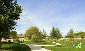 a path through a park with a house and trees at Ardeche - Gites Objectif Evasion in Montréal