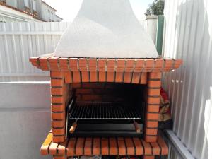 a brick pizza oven sitting on top of a patio at Casa Papagaios in Zambujal de Cima