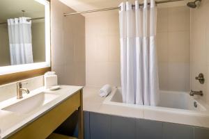 a bathroom with a tub and a sink and a mirror at Red Lion Inn and Suites Everett in Everett