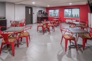 een restaurant met tafels en stoelen en rode muren bij Red Lion Inn and Suites Everett in Everett