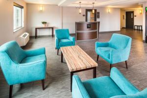 a waiting room with blue chairs and a table at Red Lion Inn and Suites Everett in Everett