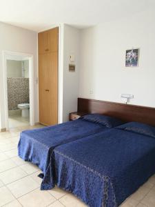 1 dormitorio con cama azul y baño en Georgia Hotel Apartments, en Protaras