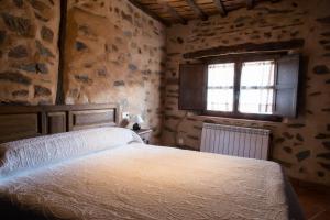 a bedroom with a bed in a room with a window at Molino del Medio in Robledillo de Gata