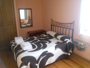 1 dormitorio con 1 cama con manta blanca y negra en Hotel Las Grandas, en Vistalegre
