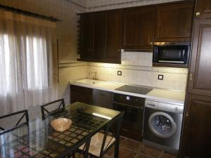 cocina con mesa, fogones y lavavajillas en Caballero de Castilla, en Santiuste de San Juan Bautista