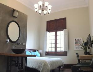 a room with a bed, a mirror, and a window at 1900 Hostel in Lima