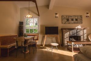 Una sala de estar con una mesa y una chimenea. en Bosque Divino Cabañas & Suites, en Valle Grande