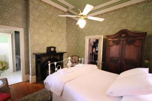 a bedroom with a white bed and a ceiling fan at Palm House in Maldon
