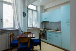 a kitchen with blue cabinets and a wooden table and chairs at Seb's Crib in Mondovì