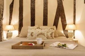 Una cama con una bandeja de comida. en Le Voyage En Isle en París
