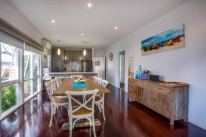 a kitchen and dining room with a wooden table and chairs at Cute Cottage on Cain - beach at end of street in Rye