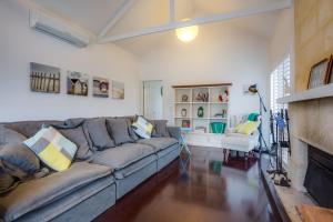 a living room with a couch and a fireplace at Cute Cottage on Cain - beach at end of street in Rye