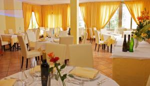 a dining room with white tables and white chairs at Hotel La Meridiana in Urbino