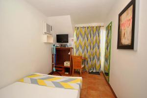 a bedroom with a bed and a desk with a television at Bluewaves Beach House in Boracay