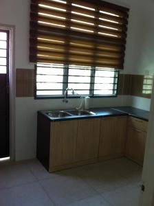 a kitchen with a sink and a window at NeoHomeStay Gapam Lestari in Malacca